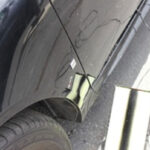 Car dent repair on black vehicle (before)